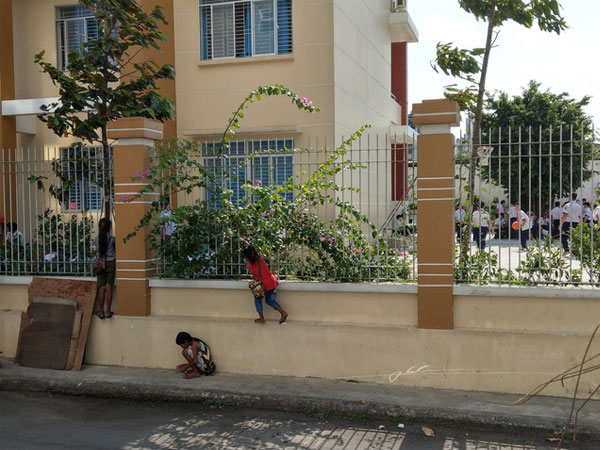 Hình ảnh 3 em nhỏ bán vé số bám hàng rào trường học để xem khai giảng gây xúc động mạnh