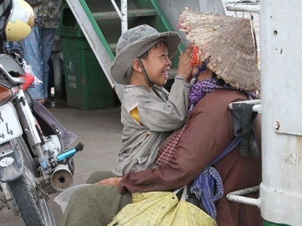Nụ cười của đứa trẻ ăn xin dành cho mẹ trên chuyến phà mưu sinh xuôi ngược - bức ảnh giản dị nhưng khiến hàng ngàn người ấm áp