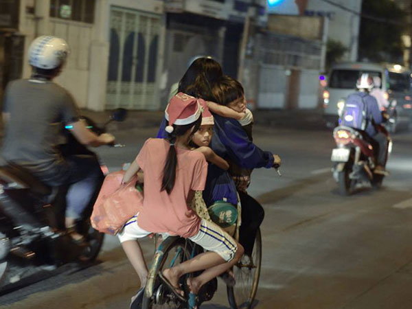 Khoảnh khắc lay động: Giáng sinh về sớm trên mái đầu trẻ thơ, mẹ chở 3 con trên chiếc xe đạp cũ