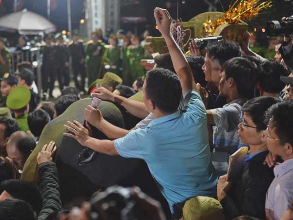Người dân ném tiền vào kiệu ấn trước giờ khai hội tại Đền Trần