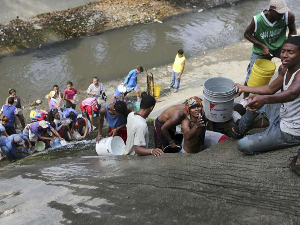 Người Venezuela hứng nước từ cống vì cúp điện
