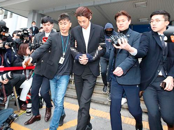 Jung Joon Young bị trói bằng dây thừng, còng tay áp giải sang phòng công tố