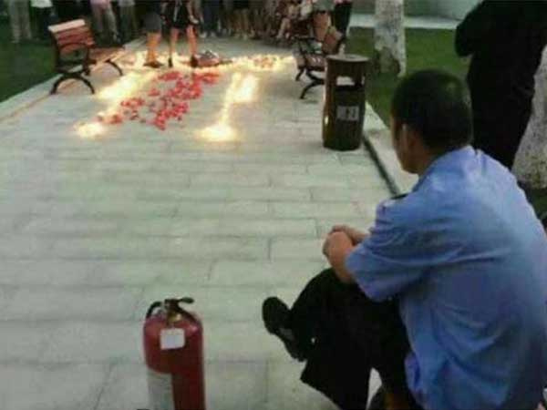 Thanh niên thắp nến tỏ tình lãng mạn dưới sân ký túc xá, bác bảo vệ có tâm chuẩn bị sẵn bình chữa cháy ngồi ngay bên cạnh