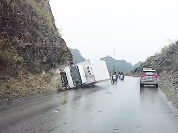 Clip: Xe tải ôm cua mất lái đâm vào sườn núi rồi lật ngang, hàng loạt xe máy may mắn thoát tai nạn trong gang tấc