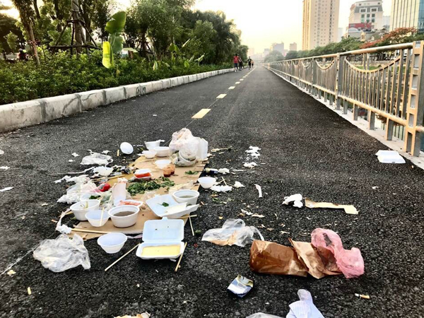 Đống bát đũa xốp, túi nilon cùng đồ ăn thừa bị bỏ lại trên đường đi bộ ven bờ sông Tô Lịch khiến nhiều người phẫn nộ