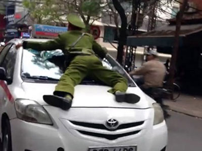 Tạm giữ tài xế taxi hất cảnh sát lên nắp ca-pô