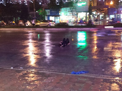 Hà Nội: Kỳ lạ người phụ nữ nằm giữa đường dưới trời mưa rét