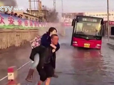 Người đàn ông chân trần cõng 14 hành khách thoát khỏi con đường ngập nước nóng