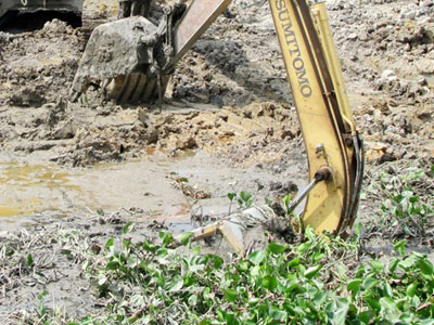 Xe cuốc lún bùn đè chết tài xế