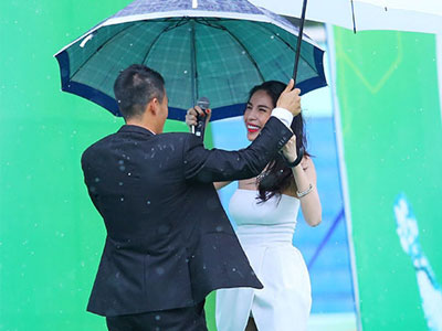 Công Vinh lên sân khấu che mưa cho Thủy Tiên
