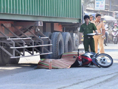 Chồng ngây dại bên thi thể vợ bị xe container cán chết