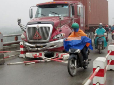 Hai người đi xe máy bị container kéo lê trên cầu Thanh Trì