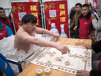 TQ: Mặc quần bơi đứng trong thùng đá lạnh chơi cờ