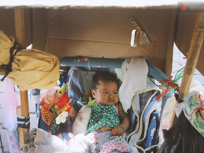 Bé gái 3 tháng tuổi nằm nôi theo bà ngoại rong ruổi khắp nơi bán vé số