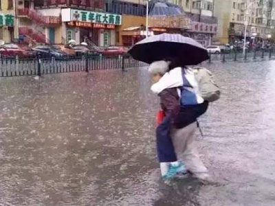 Bức ảnh bà lội nước cõng cháu gái lớn bổng đi học khiến dư luận dậy sóng