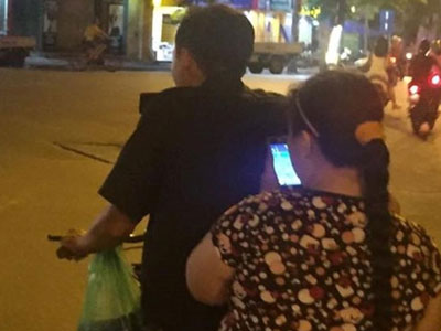 Chồng đèo vợ bằng xe đạp đi bắt Pokemon trên phố
