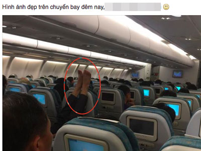 Người đàn ông gác chân lên ghế phía trước trên chuyến bay của VNA
