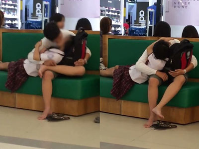 Nữ sinh mặc đồng phục hồn nhiên nằm trên lòng và ôm hôn bạn trai giữa trung tâm thương mại