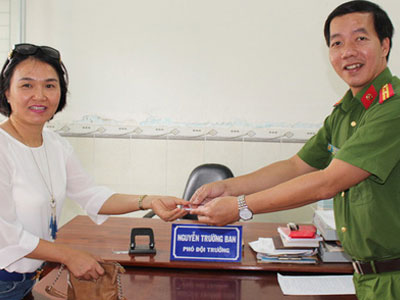 Thiếu tá công an ngồi lề đường chờ người nhận lại của rơi