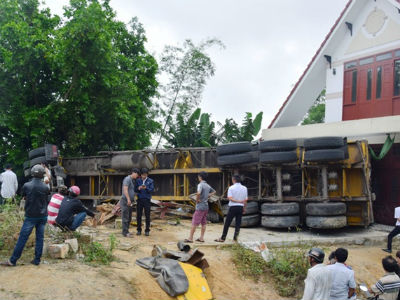 Xe container lật nhào, rơ moóc lao vào nhà dân, 2 người bị thương nặng