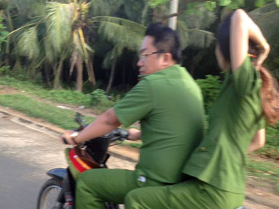 Hai người mặc sắc phục công an đi xe không đội mũ bảo hiểm