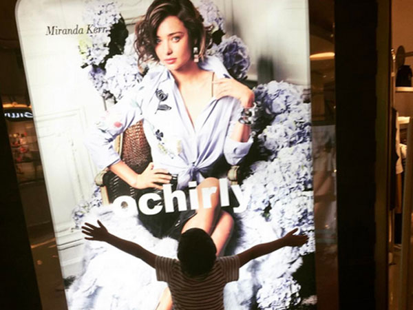 Con trai ôm chầm poster chân dung Miranda Kerr ở trung tâm thương mại