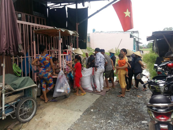 Người cha có 2 con bại não bất ngờ phát gạo từ thiện cho người dân nghèo ở xung quanh