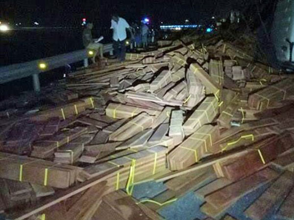 Xe đầu kéo bị lật, hàng chục tấn gỗ tràn xuống quốc lộ