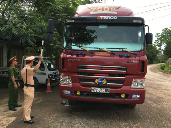 Cảnh sát giao thông mang cân xách tay đi bắt xe quá tải