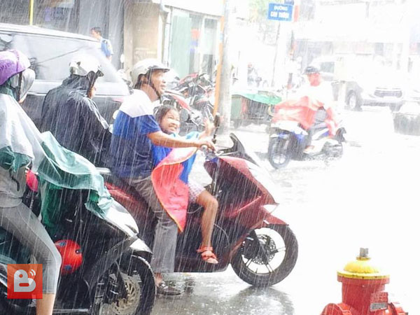 Bức ảnh ấm lòng trong Ngày của Cha: Bố ướt sũng nhường áo mưa, miễn là con đừng ốm nhé!
