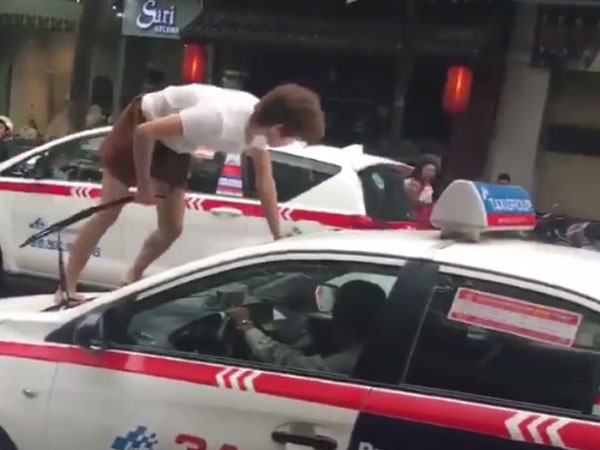 Cô gái trẻ trèo lên nóc xe taxi, náo loạn trên đường phố Hà Nội