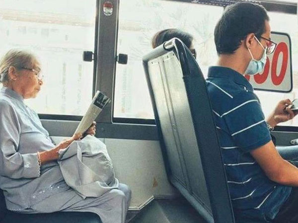 Khoảnh khắc đối lập trên chuyến bus: Một thanh thản bên tờ báo giấy, một chúi đầu vào smartphone