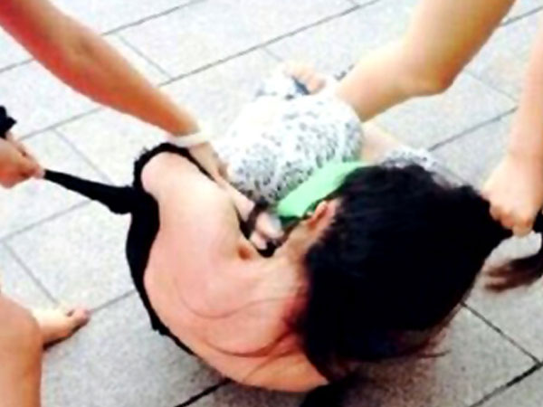 Ba mẹ con cùng lột quần áo một phụ nữ giữa chốn đông người