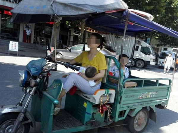 Bà mẹ gây tranh cãi khi vừa lái xe 3 bánh chở con phía sau, vừa cho bé khác bú
