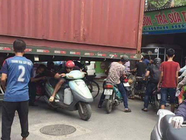 Bất chấp nguy hiểm, người dân thi nhau chui gầm container chắn ngang giữa đường để lưu thông