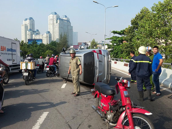 TP.HCM: Ô tô 7 chỗ lật nhào trên đường phố, tài xế bung cửa thoát thân