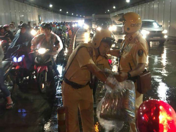 Trời bất ngờ đổ mưa giữa đêm Trung thu, 2 CSGT phát áo mưa miễn phí cho người dân trong hầm Thủ Thiêm