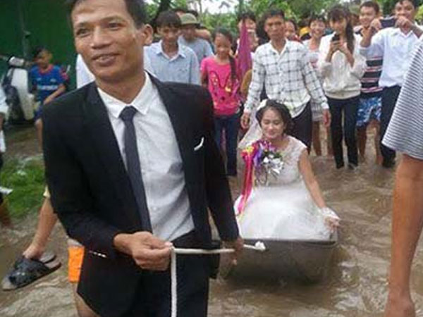 Cô dâu ngồi thuyền hoa khi đường ngập lụt